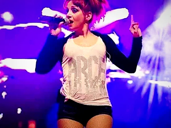 Eva Llort singing on stage under purple lights